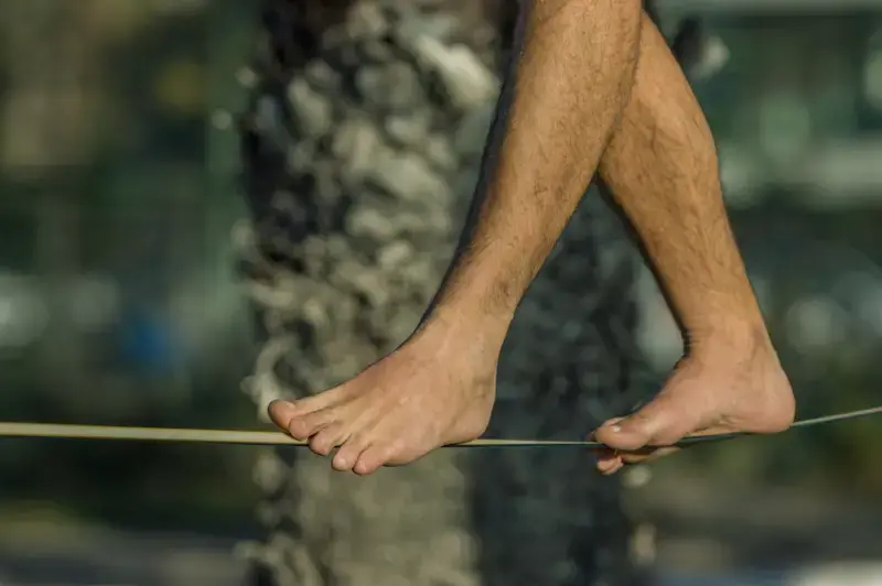 Close-up of feet walking along a tightrope demonstrating balance, stability and proprioception
